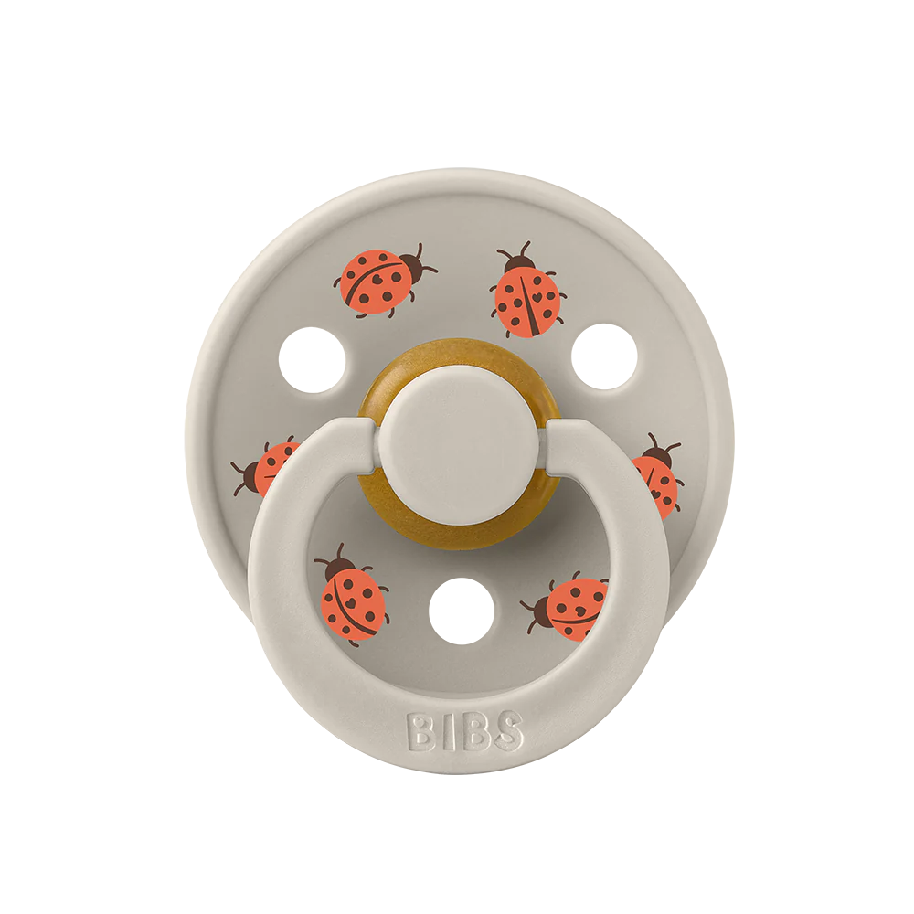 À l'unité : Suce Bibs (ronde) studio  sable avec coccinelles